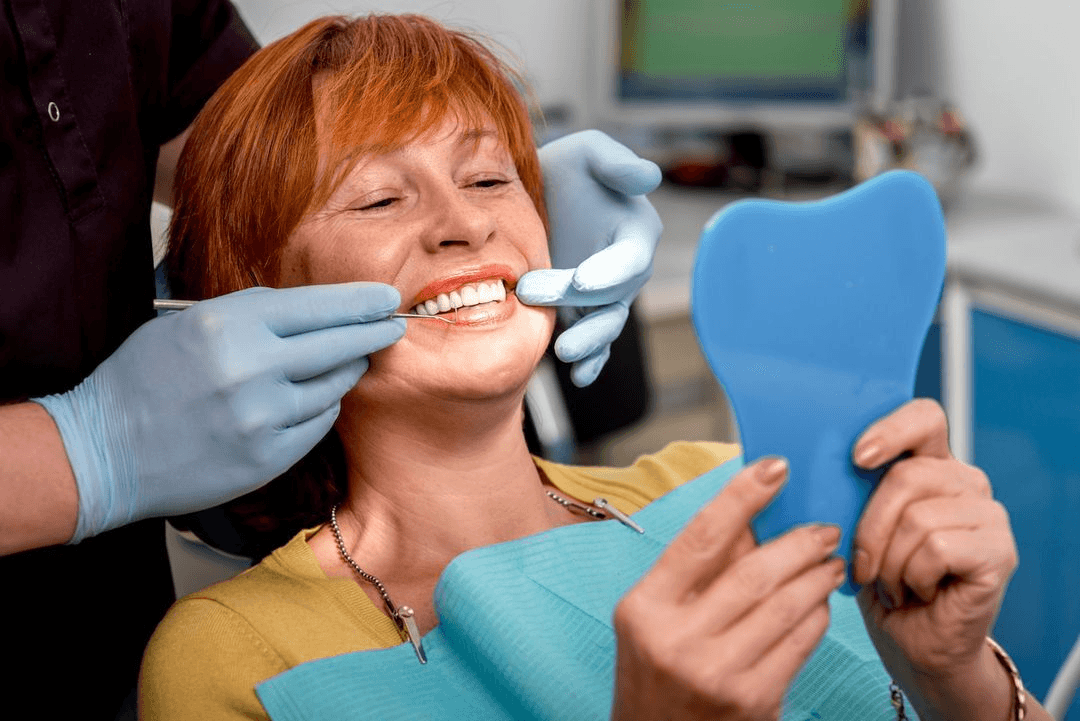 Patient smiling while reviewing her new smile after full mouth reconstruction at Advanced Dental Care Leesburg